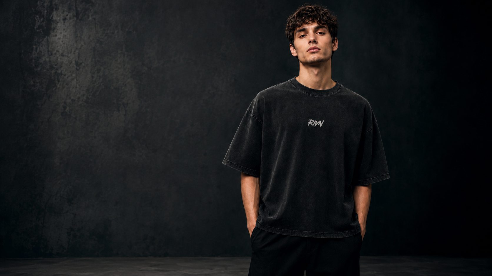 First Cut heavyweight boxy tee, washed matte black, worn front view — RIVN FC-001